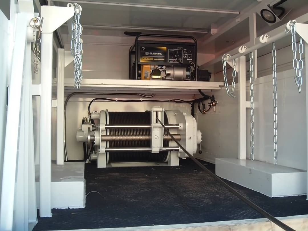 A BRADEN BP200C cable-pulling winch mounted inside a utility truck body, with wire rope spooled on its drum and a Subaru generator on a shelf above